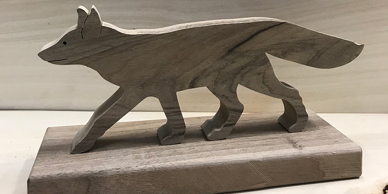 Ręcznie wycinana z drewna orzechowego figurka zwierzęcia leśnego (na zdjęciu lis).